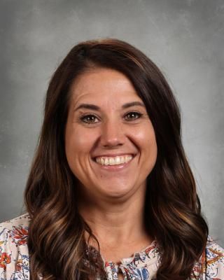 A woman in a pink sweater is smiling for the camera.