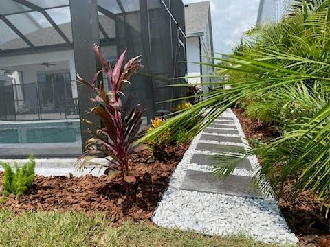 There is a walkway leading to a pool in the backyard.