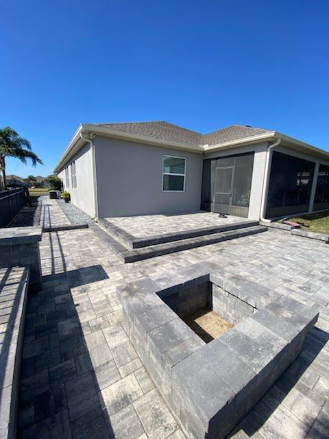 A house with a patio and a fire pit in front of it.