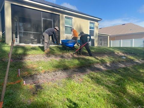 A group of men are working on a lawn in front of a house.