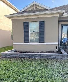 A house with a brick wall in front of it and a window.