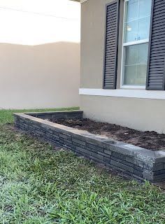 A brick wall is being built in front of a house.