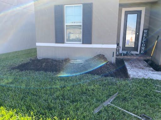 A house with a rake and shovel in front of it.