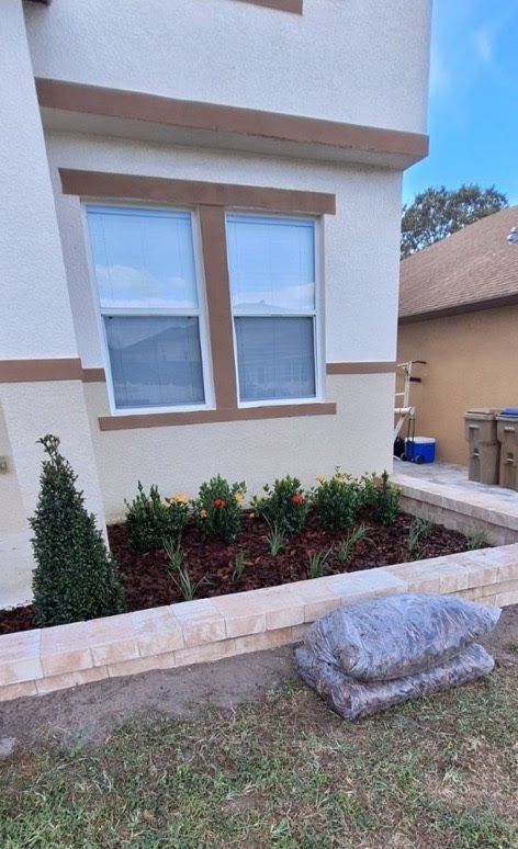 A house with a garden in front of it and a window.