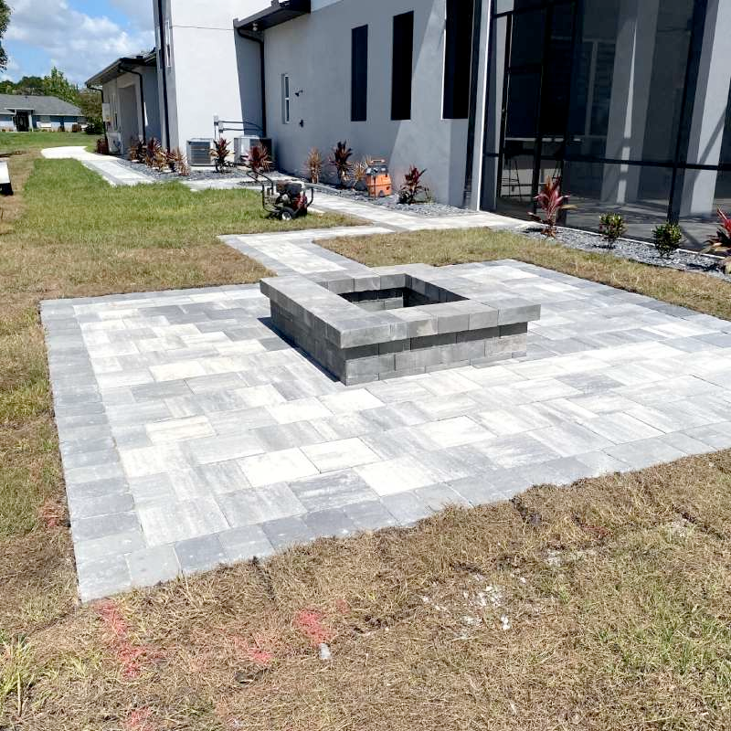 A patio with a fire pit in the middle of it