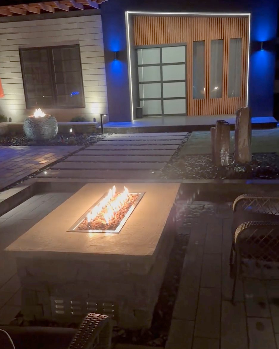 A fire pit is sitting on a table in front of a house.