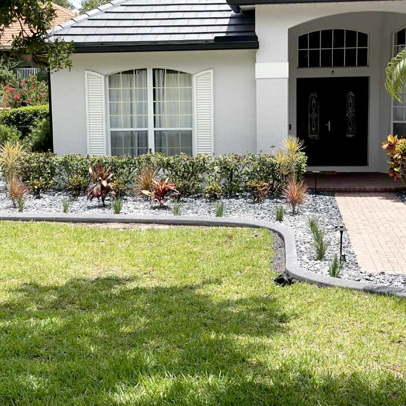 A white house with a black door and a brick walkway