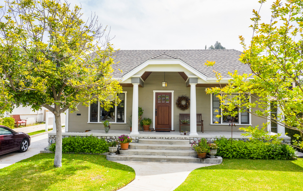 Three people in a bright office setting. Woman gestures, man smiles, and person with red hair in the foreground.