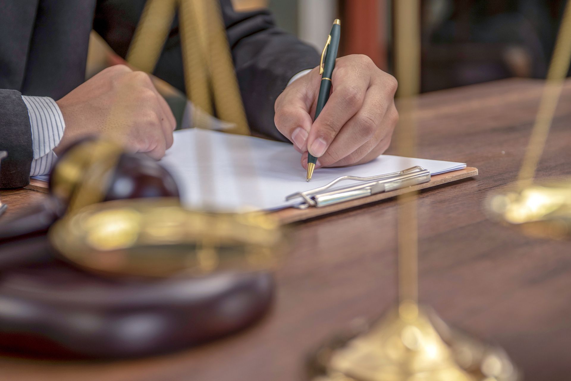 A man is writing on a clipboard with a pen.