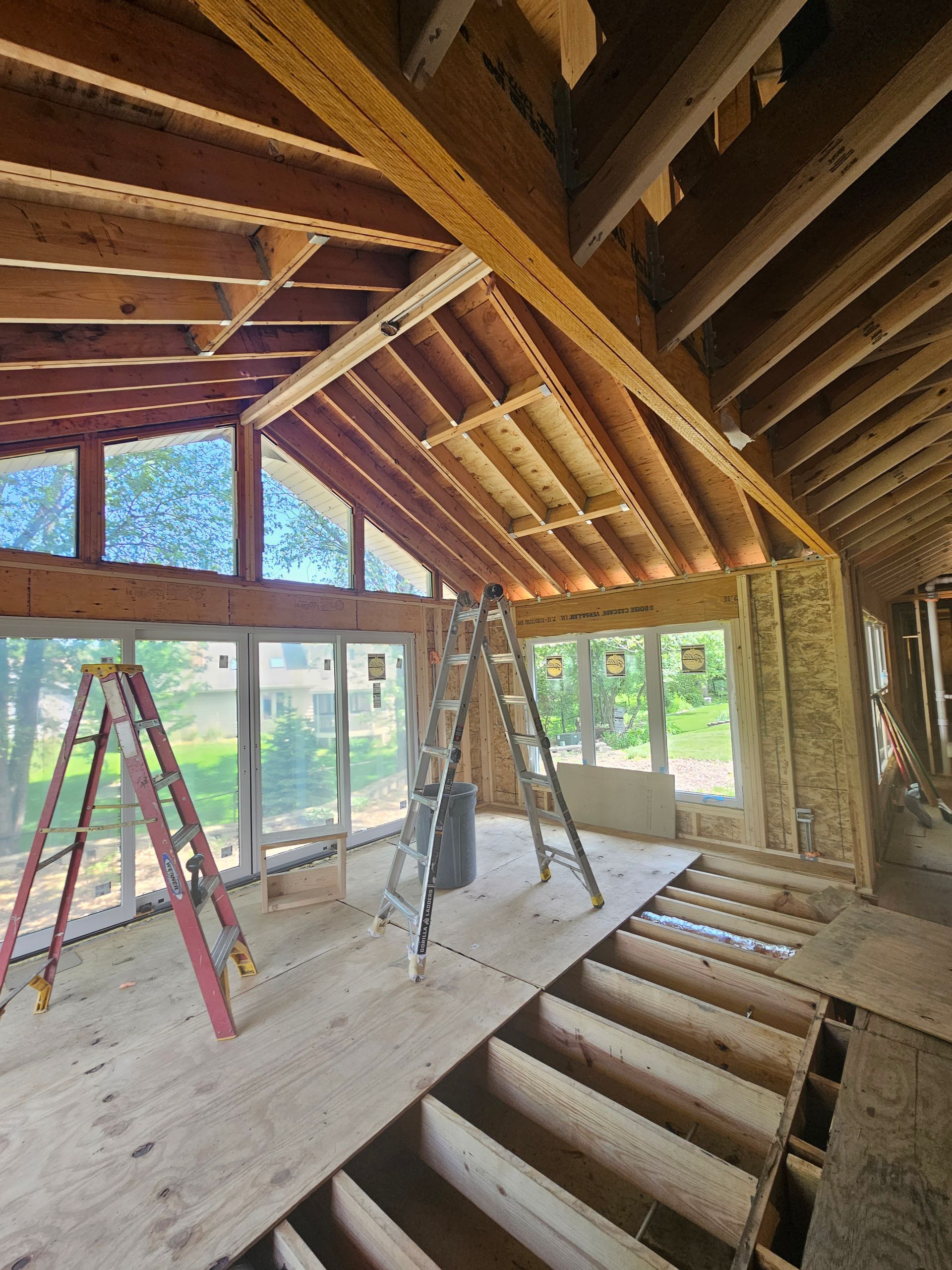 A ladder is sitting in the middle of a room under construction.