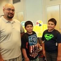 Man with two boys in front of a 