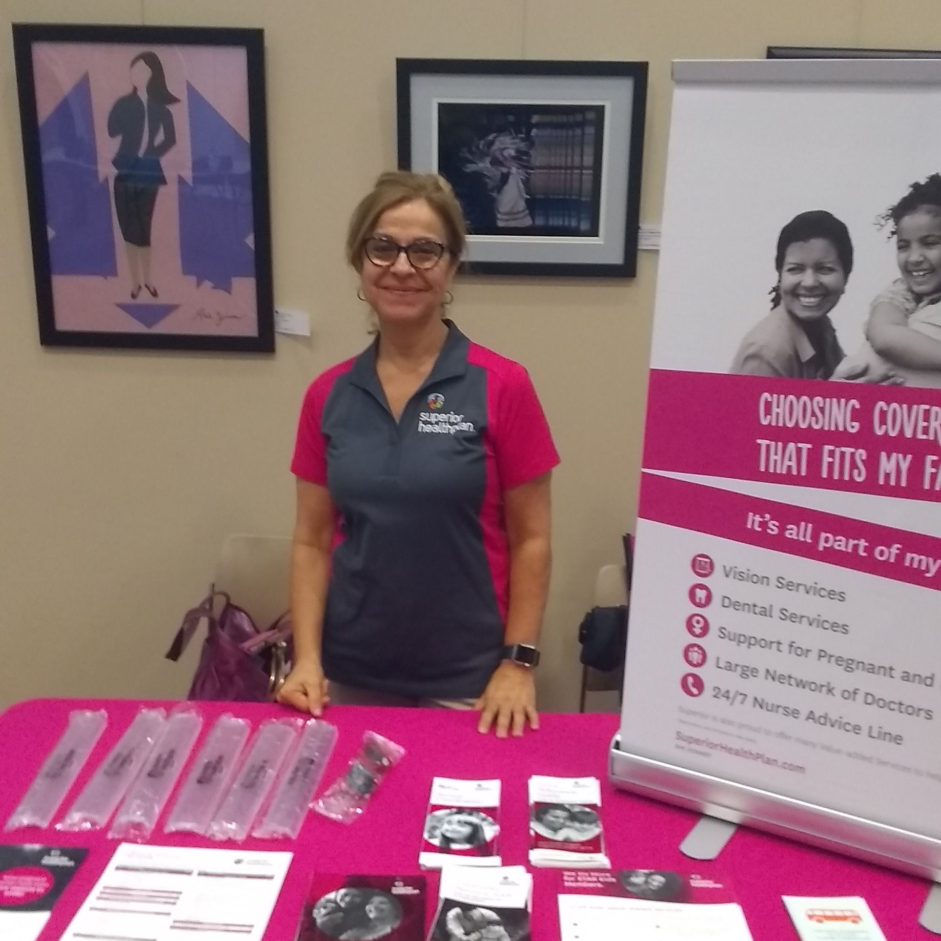 Woman at a table with health insurance information and promotional materials.