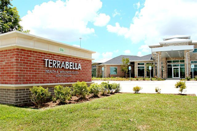 Sign for Terrabella Health and Rehab Services at a building with brick facade under blue sky.