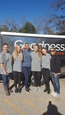 Six people standing in front of a food truck with the word