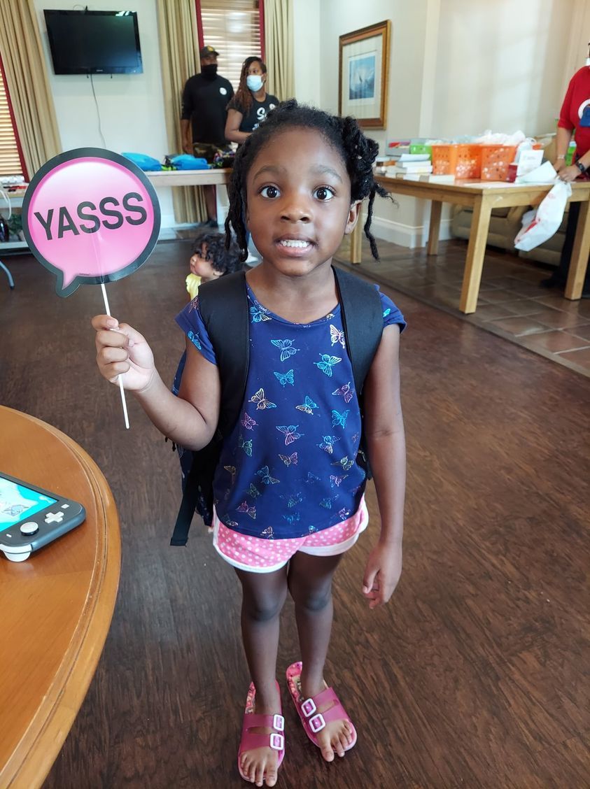 Young child with backpack holds 