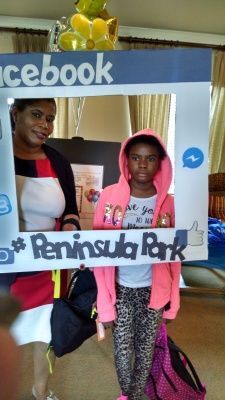 Woman and girl pose behind a Facebook-themed photo frame, Peninsula Park is written on it.