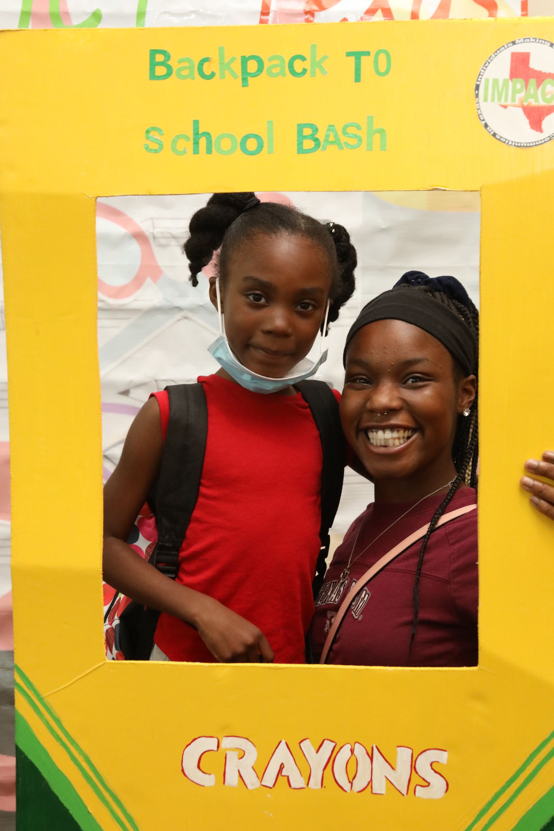 Two smiling people posing in a yellow frame at a 