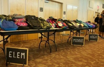 Backpacks on tables labeled 