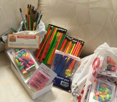School supplies, including pencils, pens, and erasers, are bundled together.