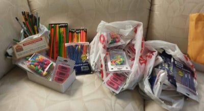 Various art supplies, including brushes, pencils, and erasers, are scattered on a white surface, presumably a couch.