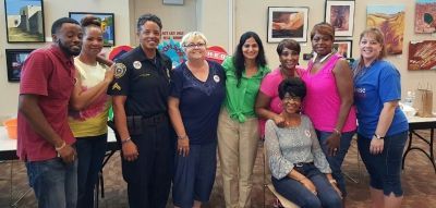 Group of people posing together indoors, with artwork on the walls.