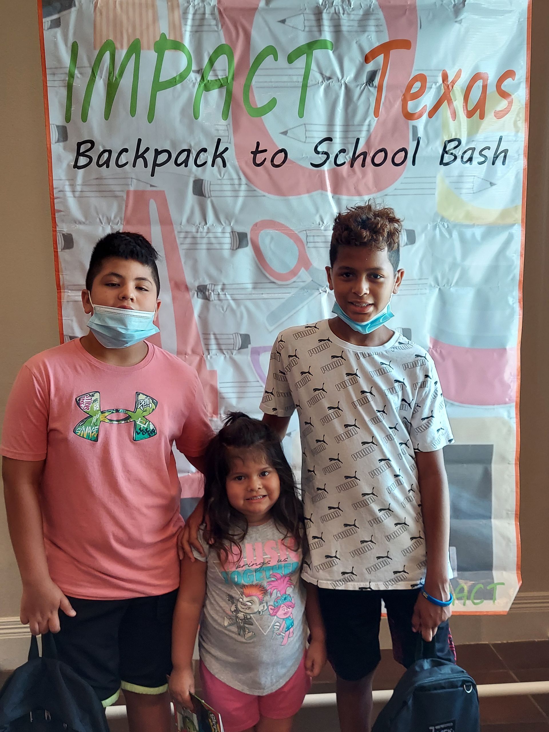 Three children stand in front of a 