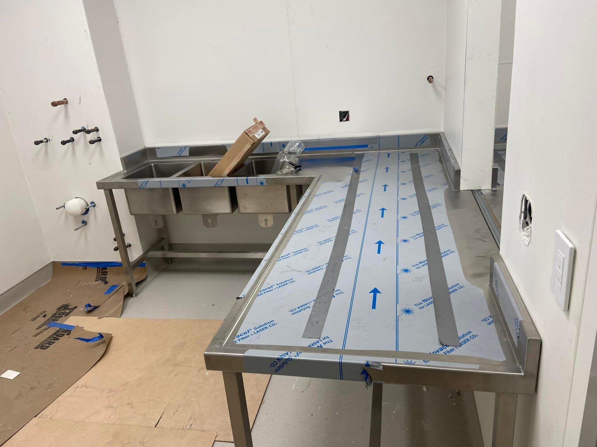 A kitchen with a stainless steel table and sinks.