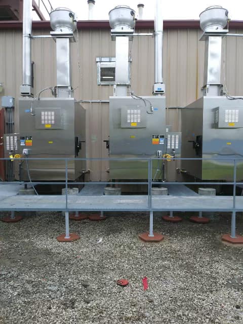 A row of stainless steel boxes are lined up in front of a building