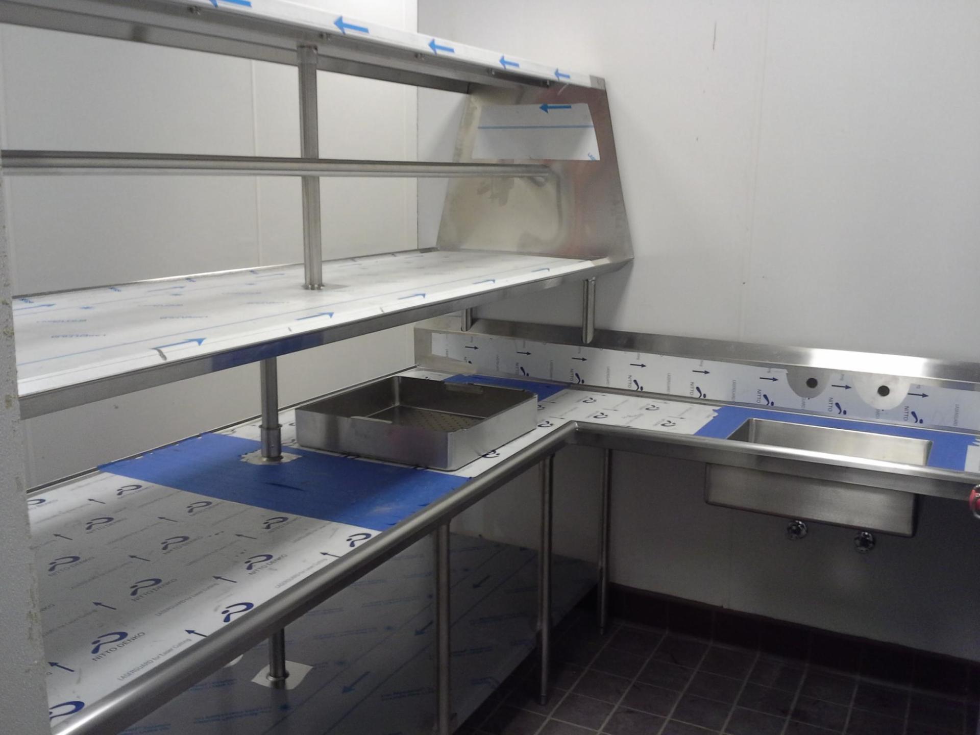 A kitchen with stainless steel shelves and a sink