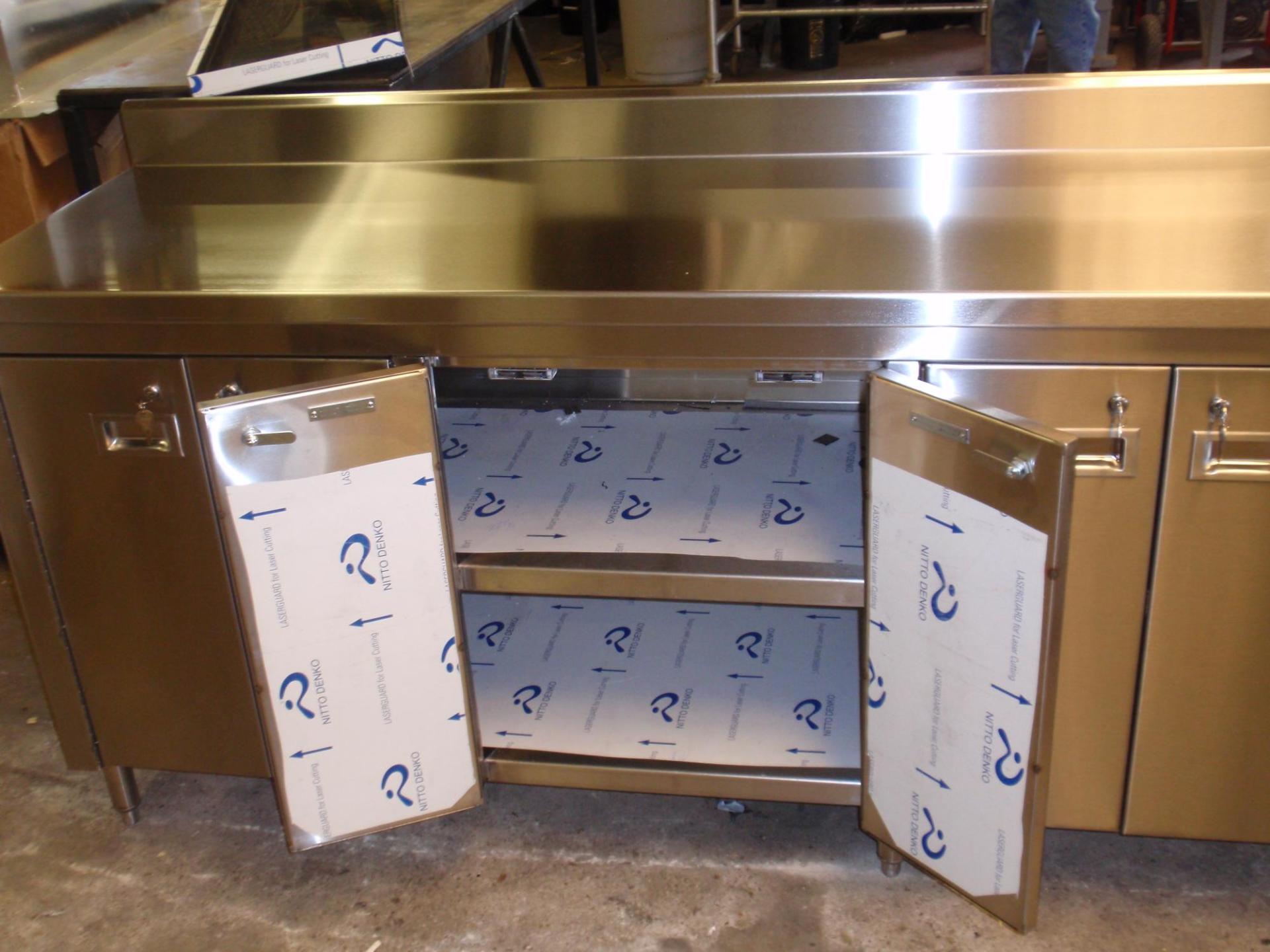 A stainless steel counter top with the doors open
