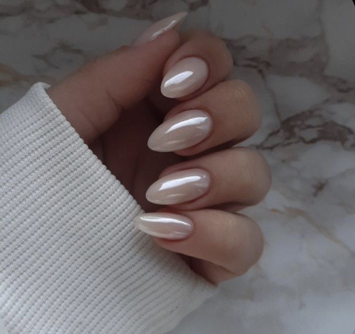 A woman 's hand with long nails and a white sweater