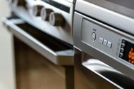 Close-up of a stainless steel oven and range with knobs and digital display.