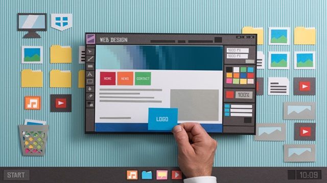 Hand placing a blue button on a web page mockup with dashboard icons on a desktop interface