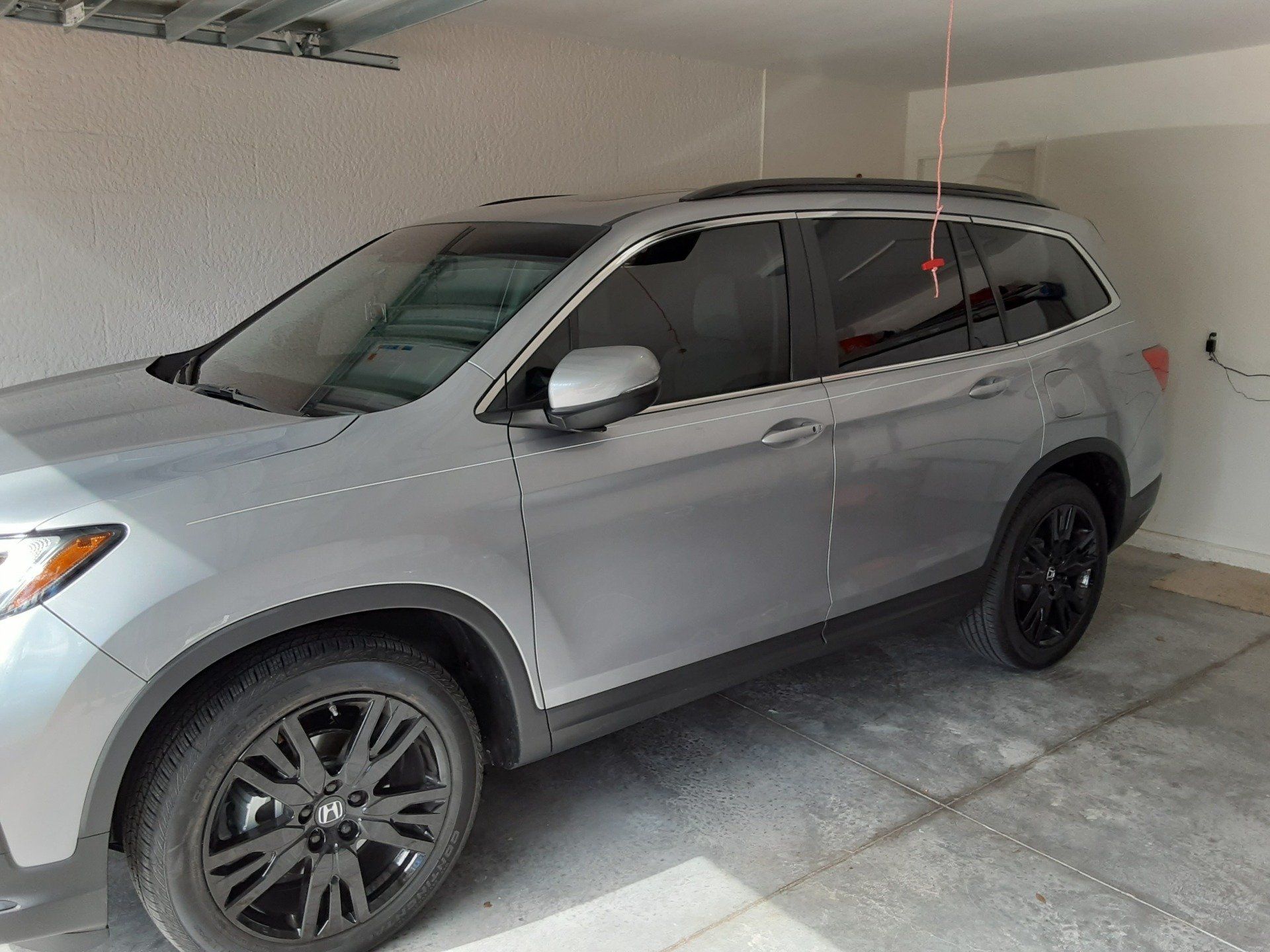A silver suv is parked in a garage.