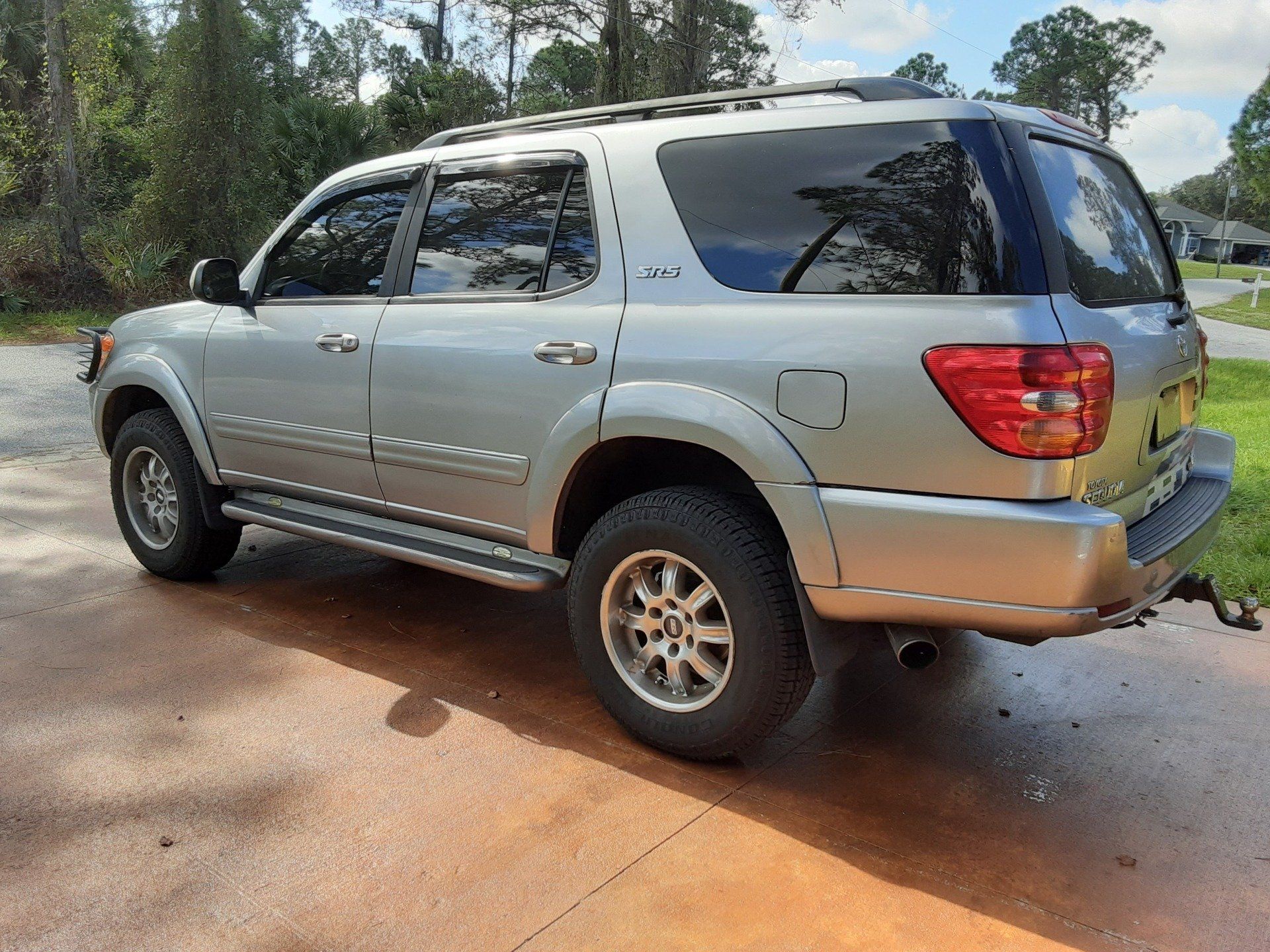 A silver suv is parked in a driveway.