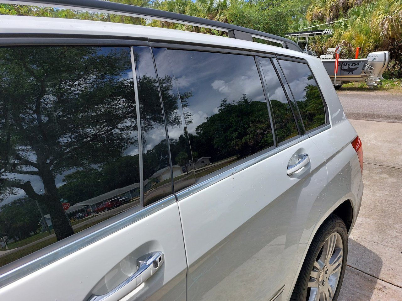 A silver suv with a roof rack is parked in a parking lot.