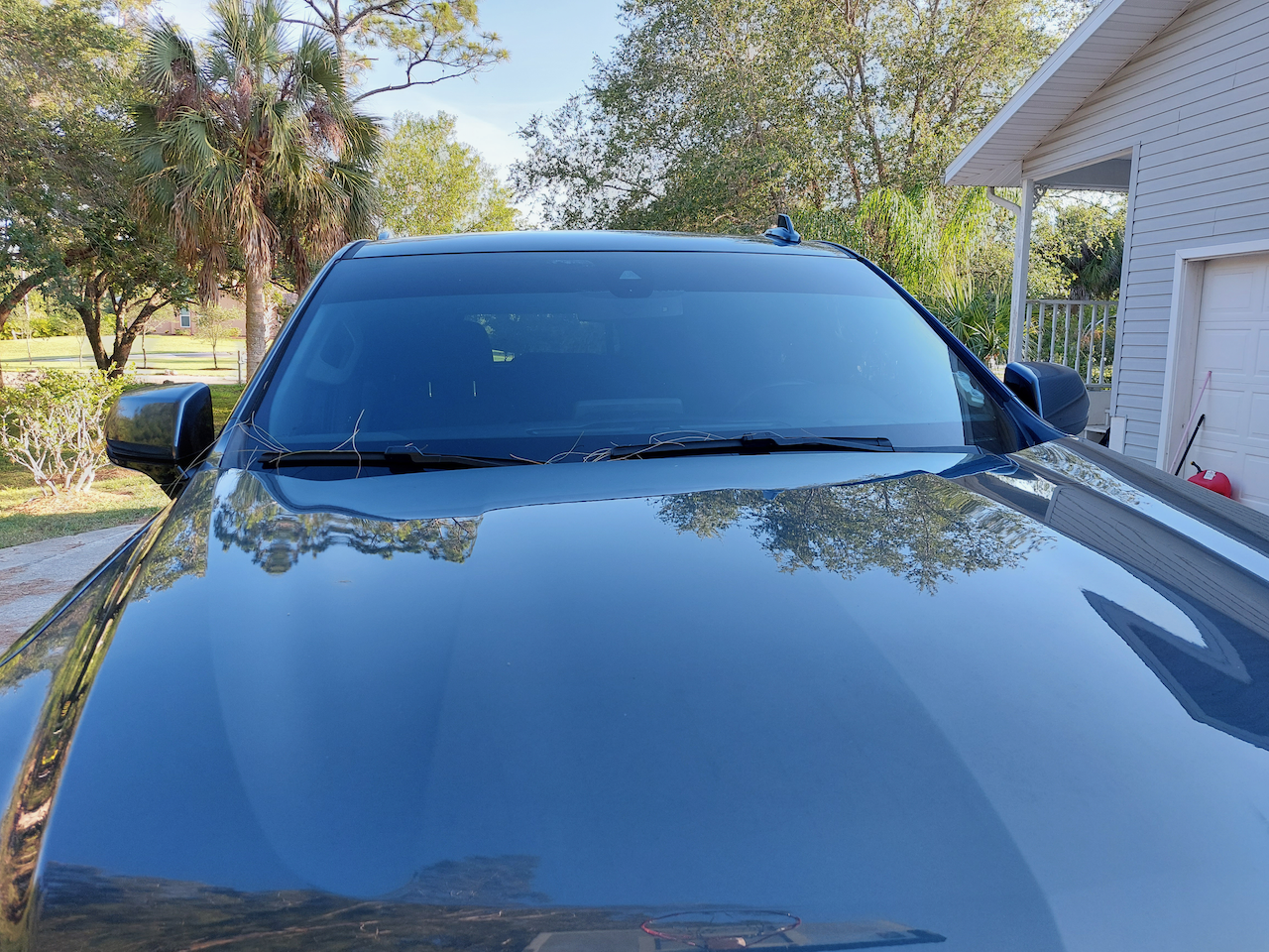 A black suv is parked in front of a garage.