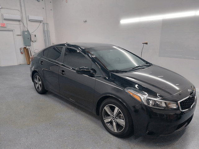 A black car is parked in a garage.