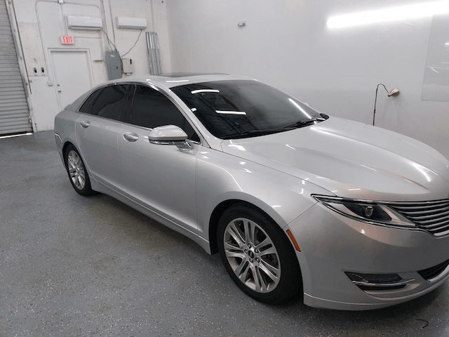 A silver car is parked in a garage.
