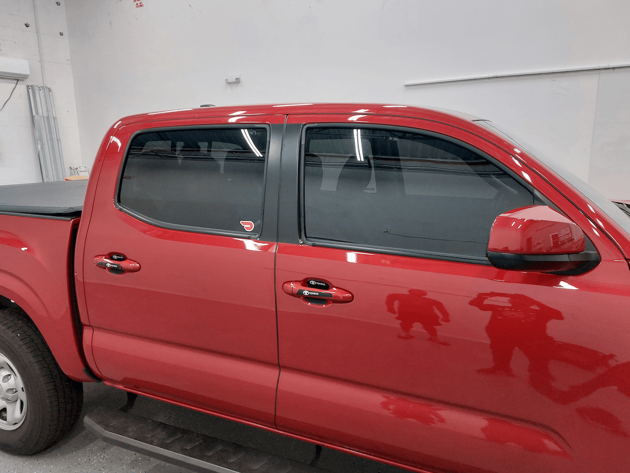 A red pickup truck is parked in a garage.