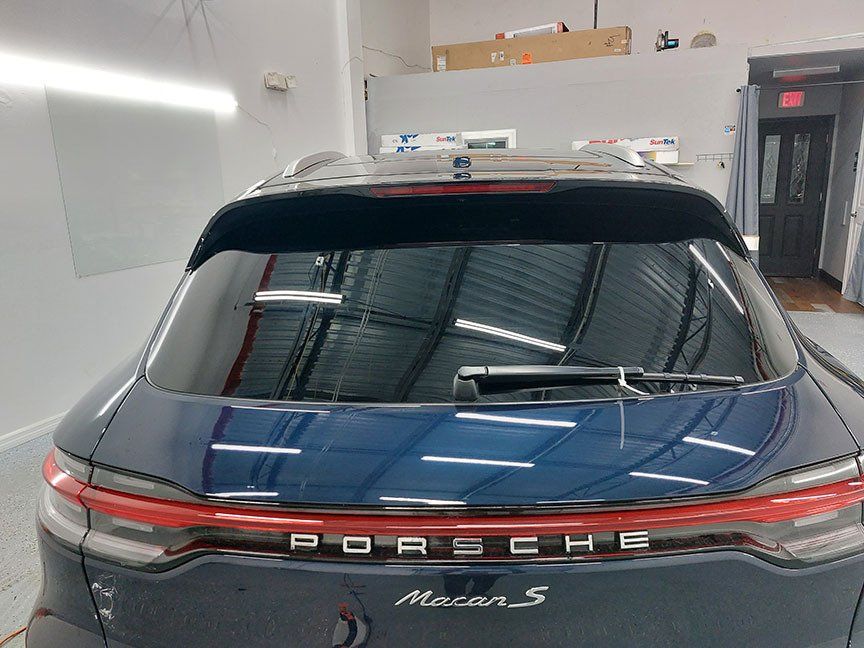 A black porsche macan s is parked in a garage.