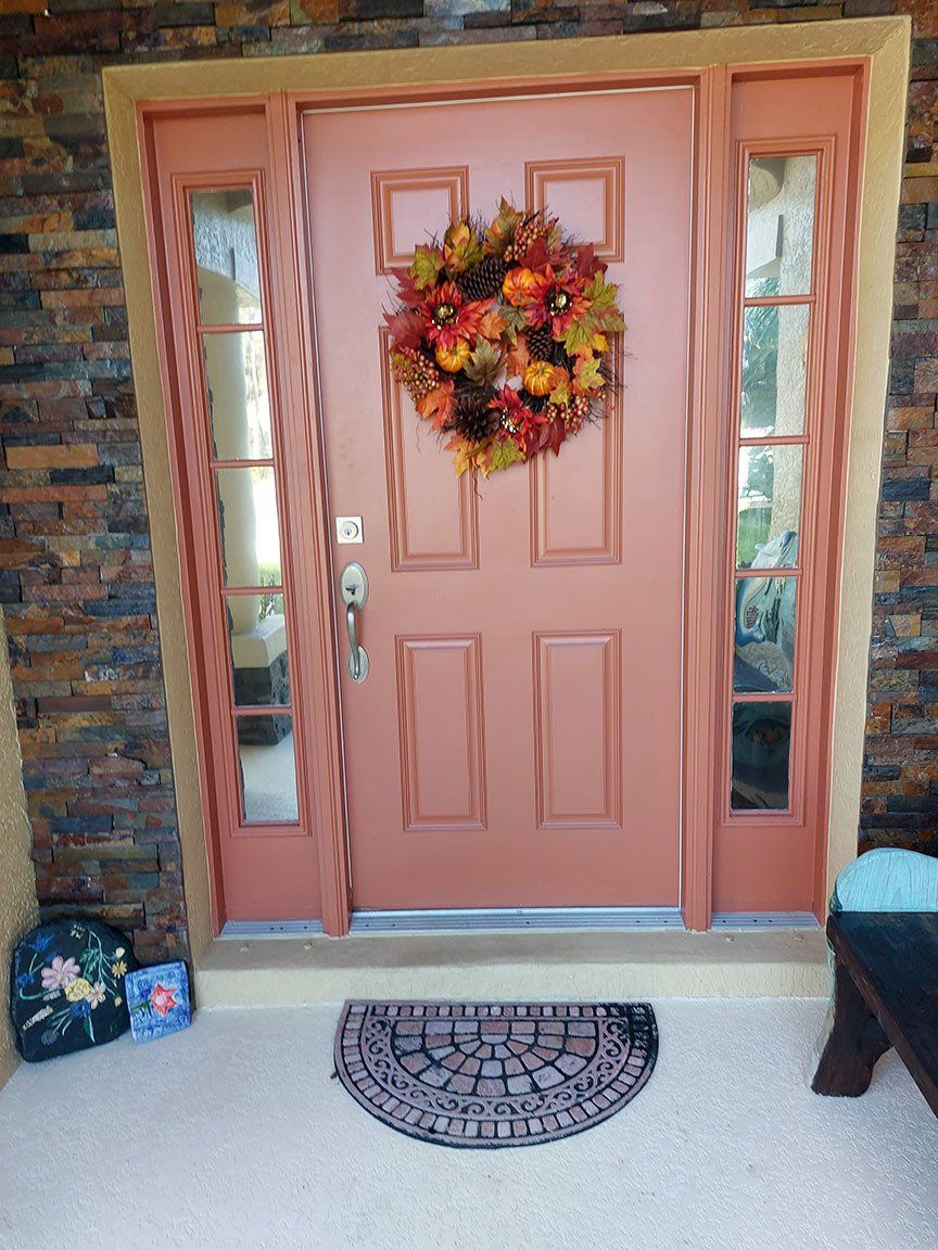 The front door of a house with a wreath on it.