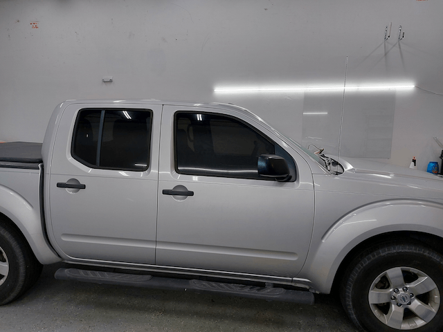 A white pickup truck is parked in a garage.