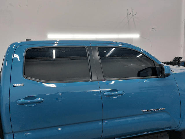 A blue truck is parked in a garage.