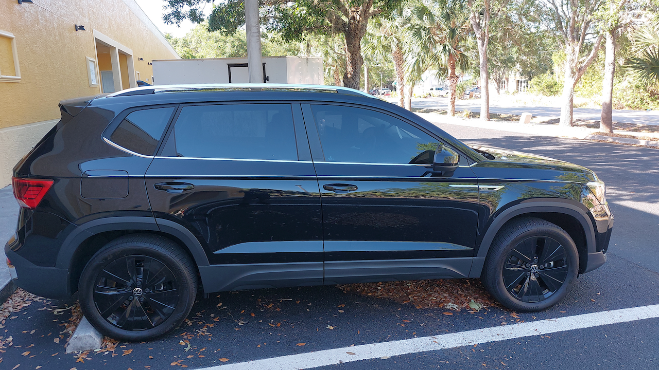 A black suv is parked in a parking lot next to a building.