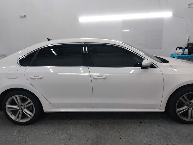A white car with tinted windows is parked in a garage