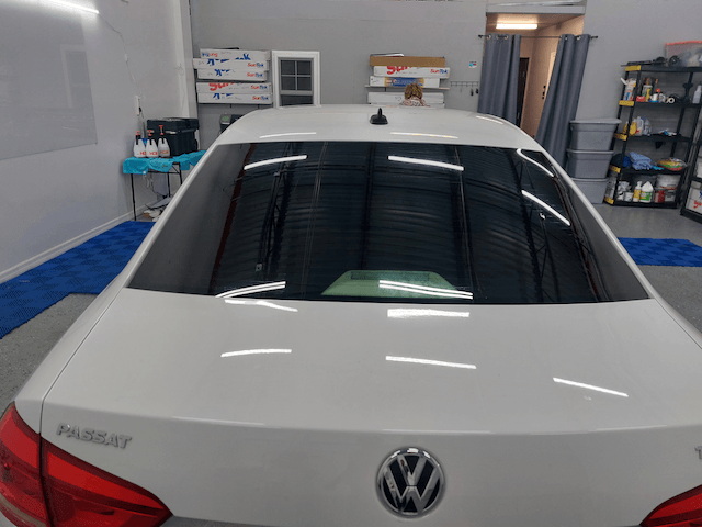 A white volkswagen passat is parked in a garage