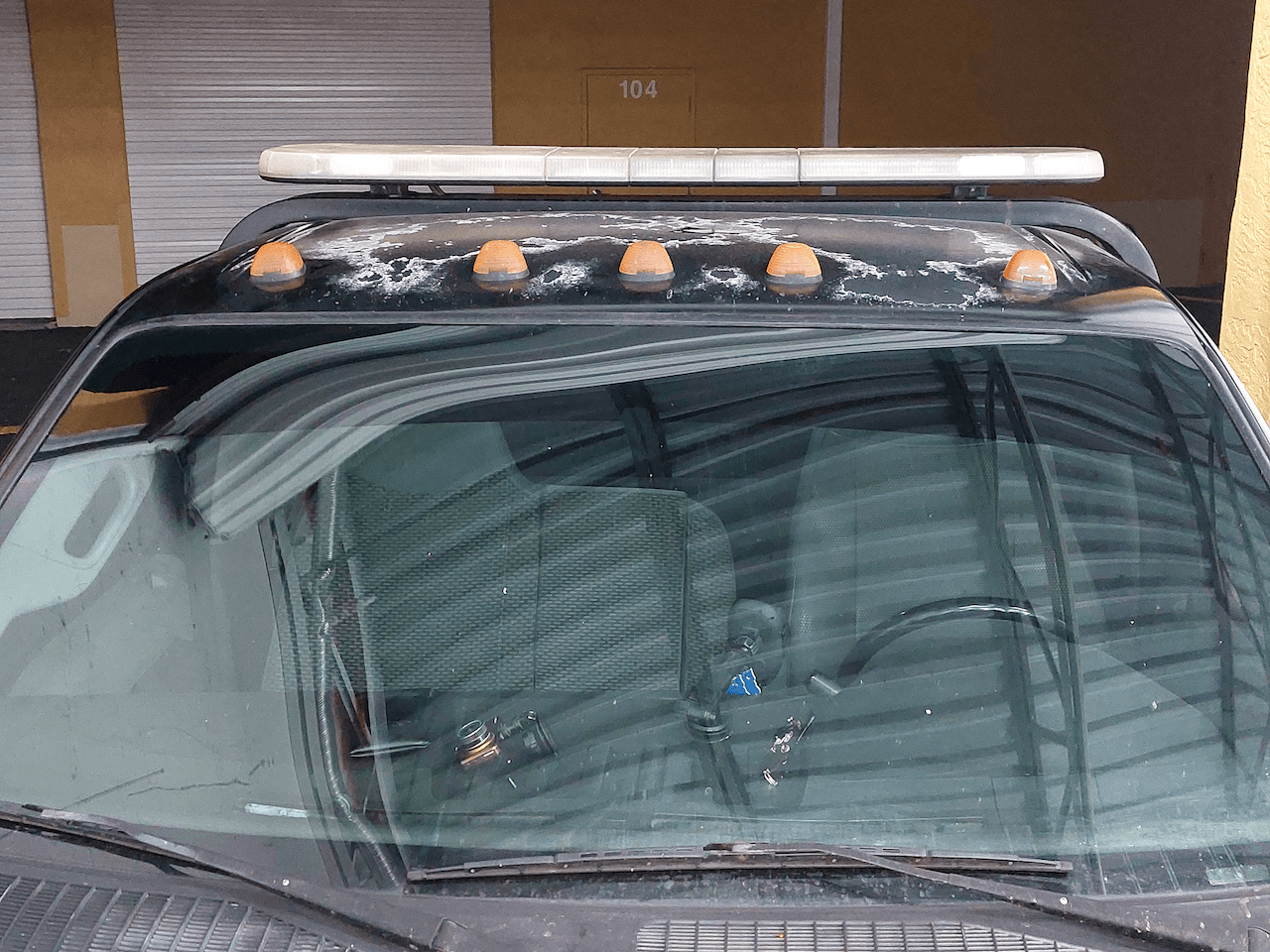 A truck with a light on top of it is parked in front of a building.