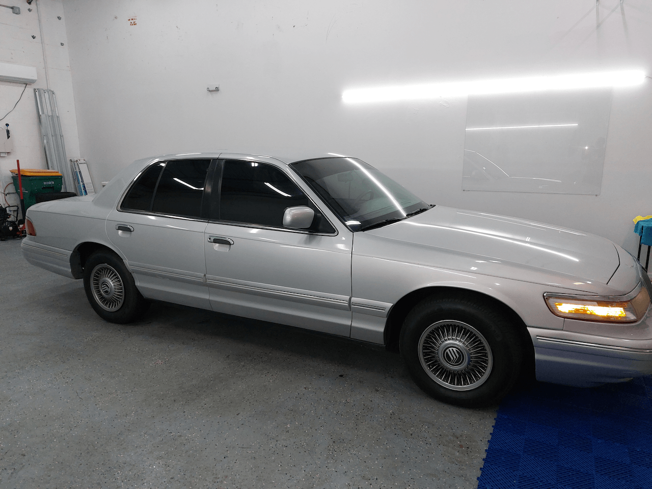 A silver car is parked in a garage.