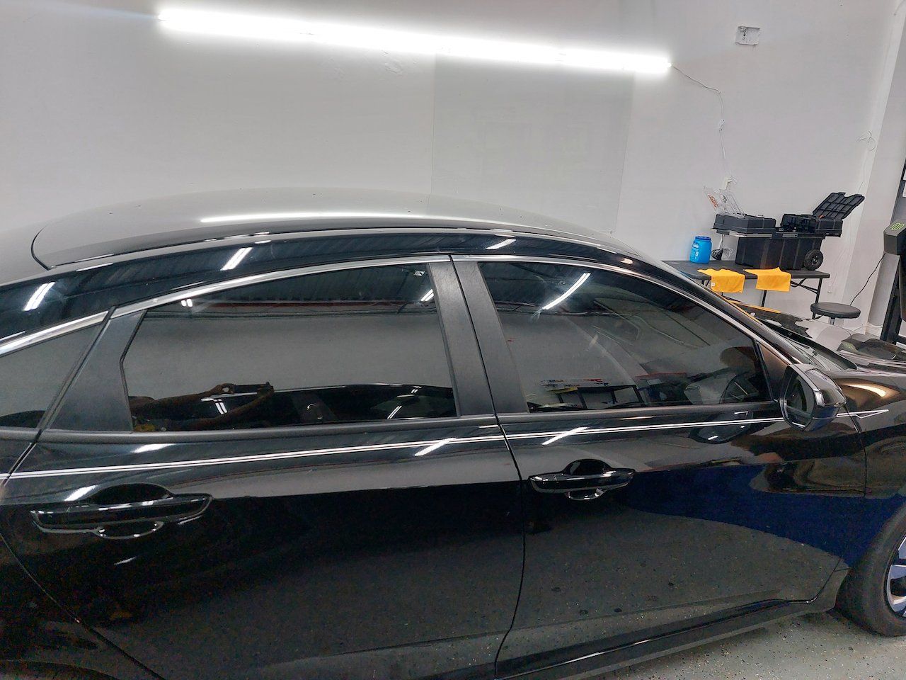 A black car is parked in a garage.